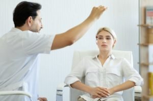 Hypno Therapist conducting hypnosis therapy on young woman
